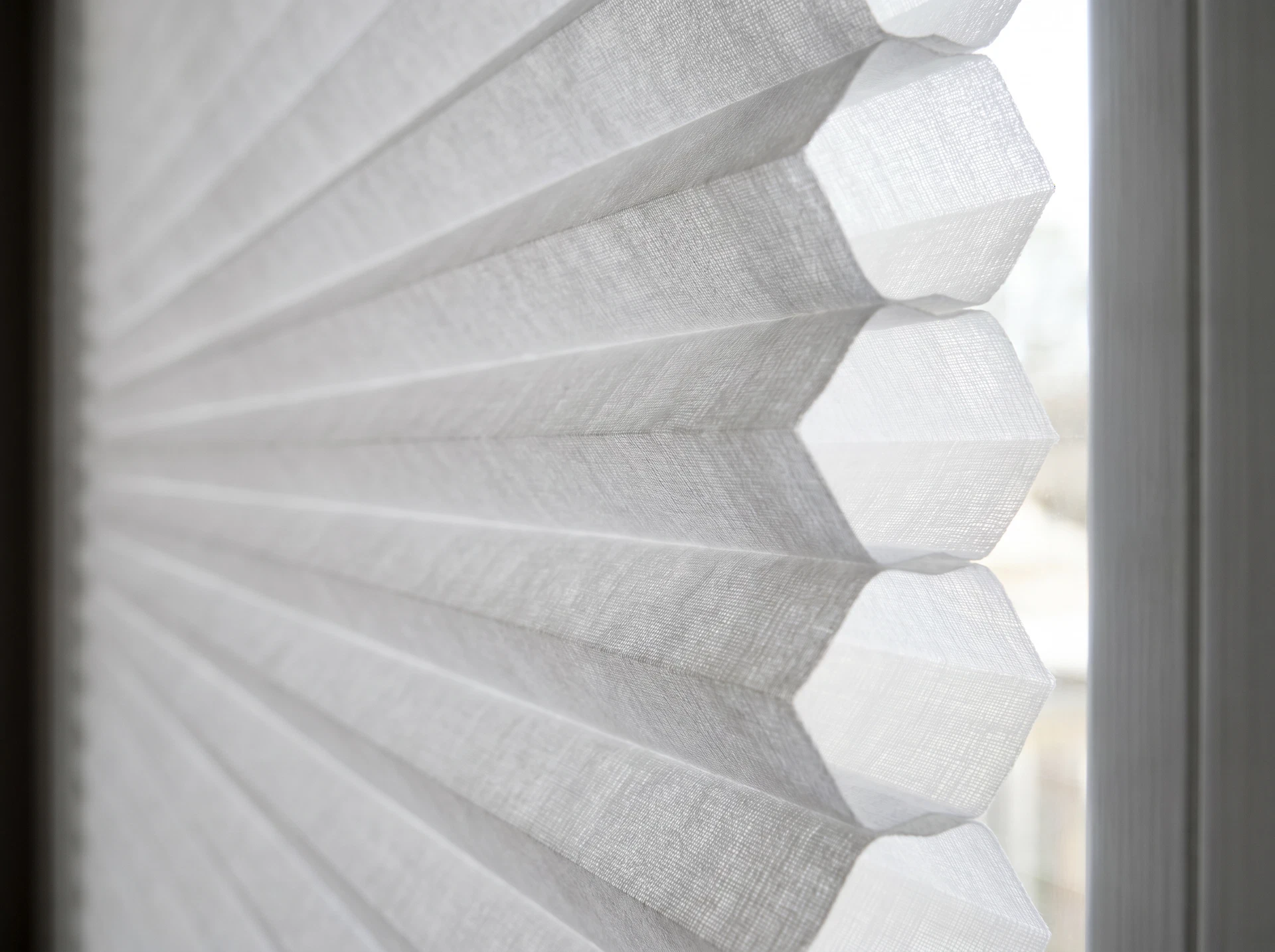 Close-up side view of honeycomb cellular window shade showing the distinctive air pocket cells that provide insulation
