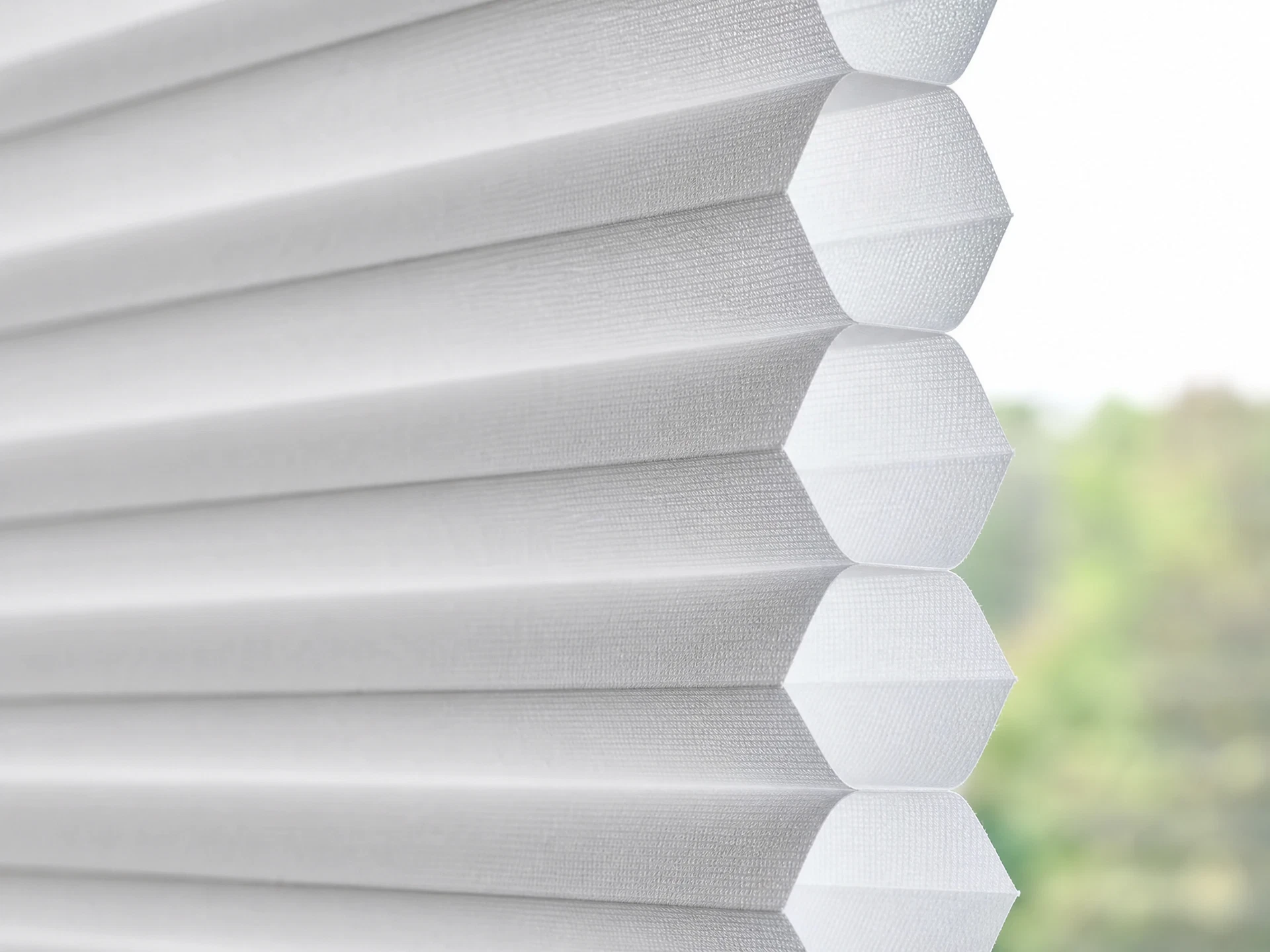 Close-up of honeycomb cellular window shade fabric showing the distinctive hexagonal cell structure