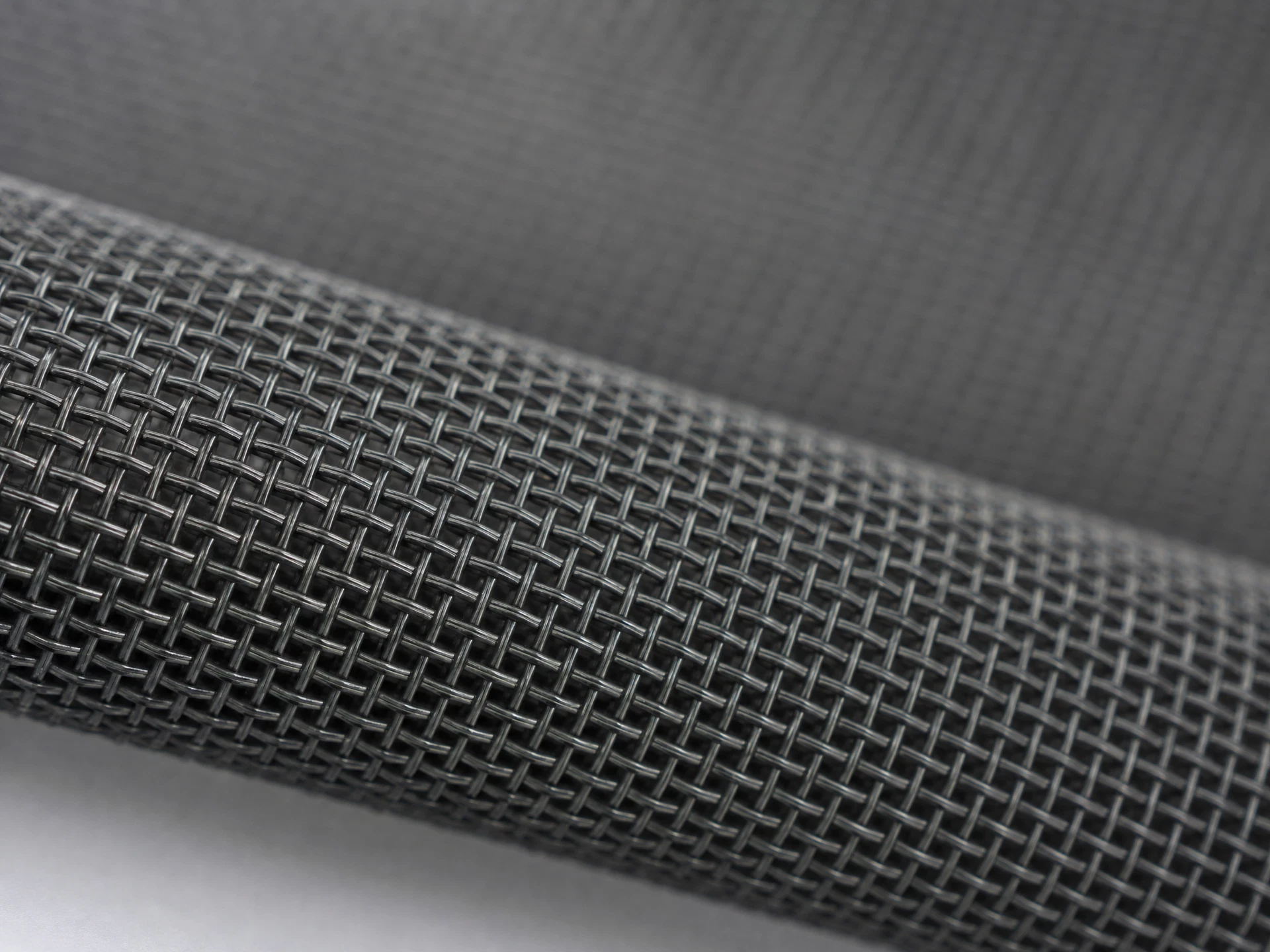 Extreme close-up macro photograph of charcoal fiberglass window screen mesh